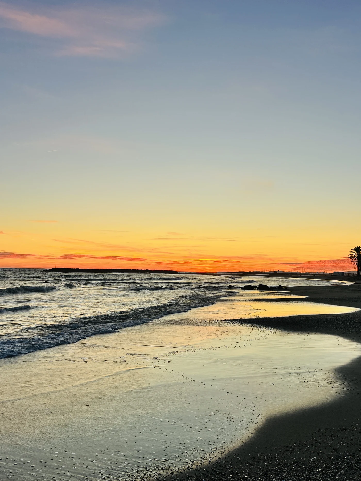 Cunit beach at golden-hour sunset, waves along the shore