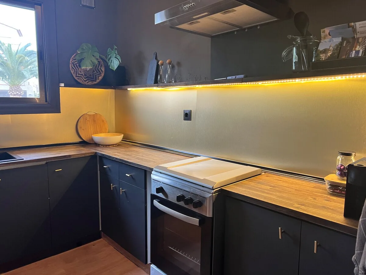 Wider kitchen view with oven, corner counter and a bright window